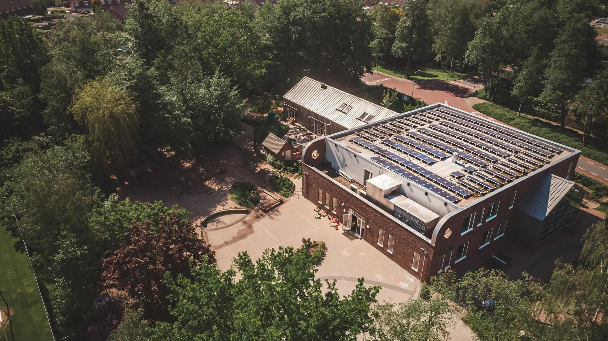 Schule mit Photovoltaikanlage auf dem Dach, von oben fotografiert